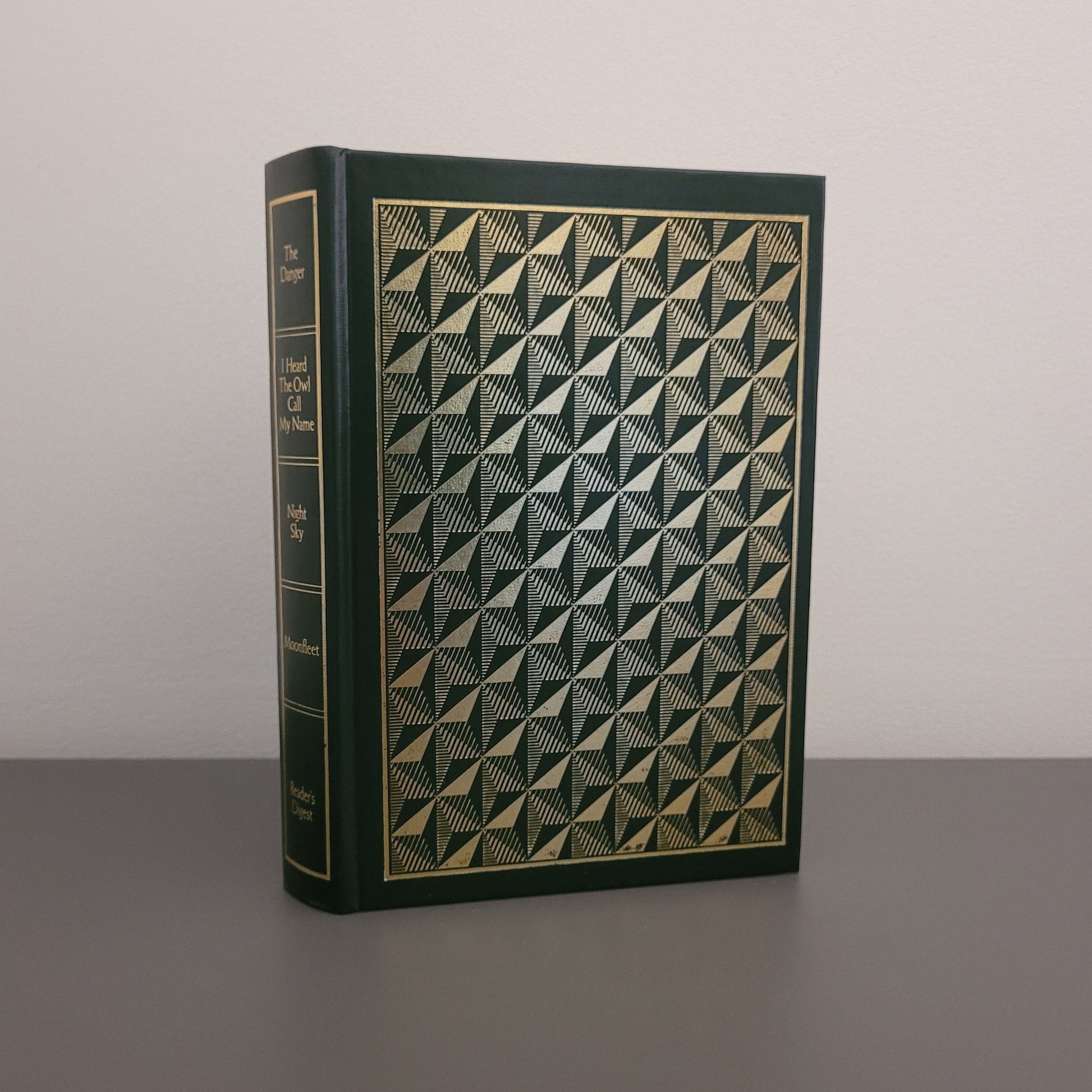 A picture of the front of the book fold - a dark green hardback, with a metallic pattern on the front.