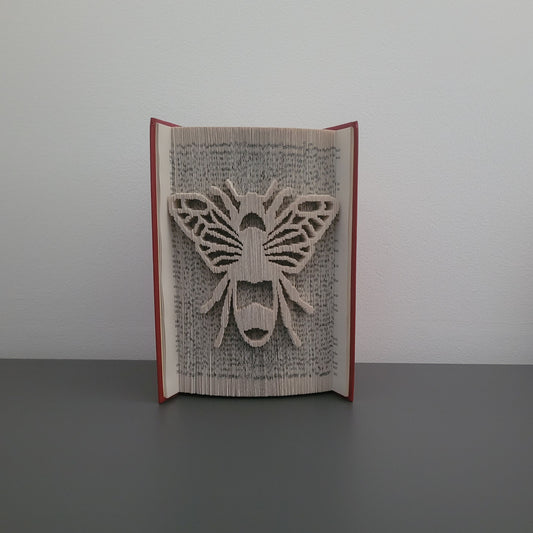 A picture of a book fold with a bee on the front.