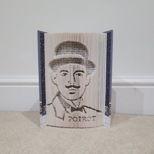 Book Fold of Agatha Christie's, Hercule Poirot. Picture shows a hardback book open, with a picture of "Poirot" on the side.