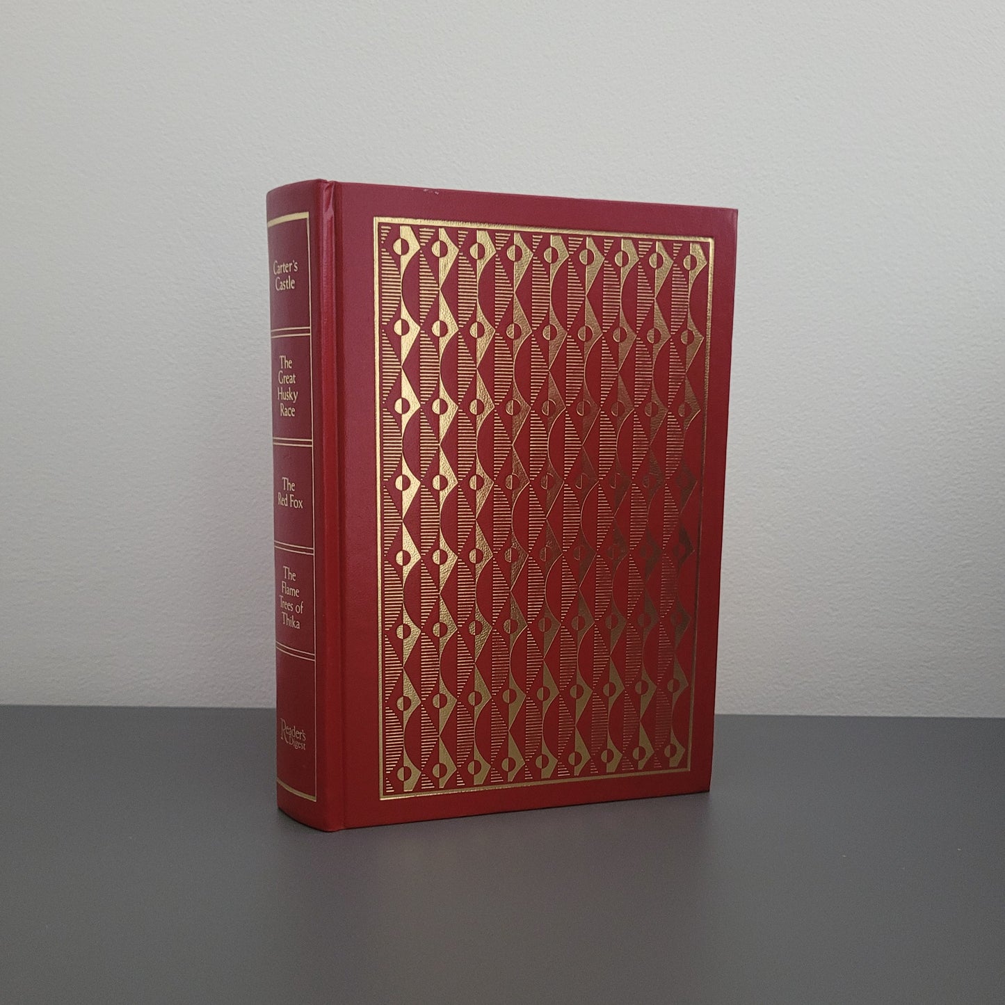 A picture of the front of the book fold - a red hardback book, with a gold pattern on.