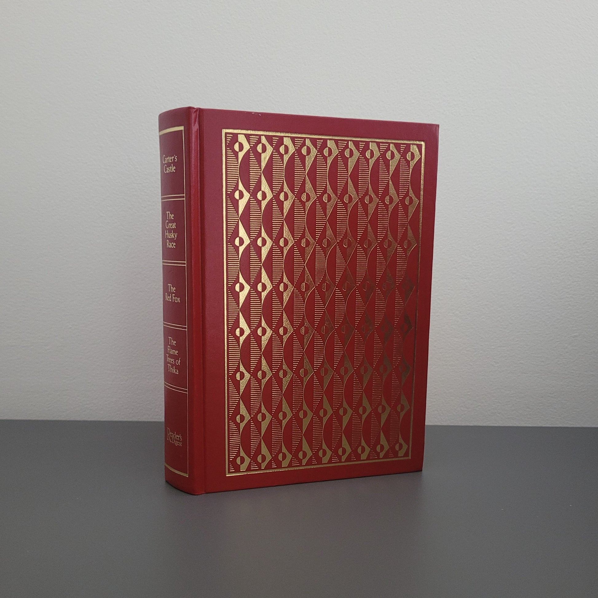 A picture of the front of the book fold - a red hardback book, with a gold pattern on.
