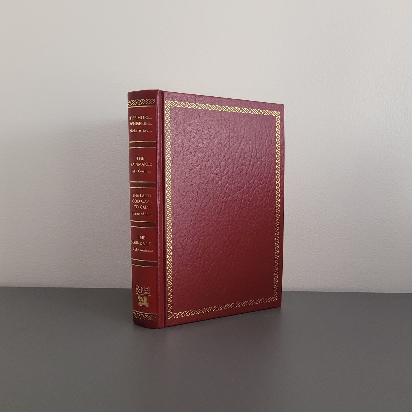 The front of the book fold, showing a red hardback book with a golden border.
