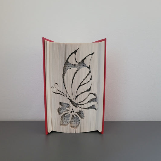 A book fold with a picture of a butterfly on a flower on.