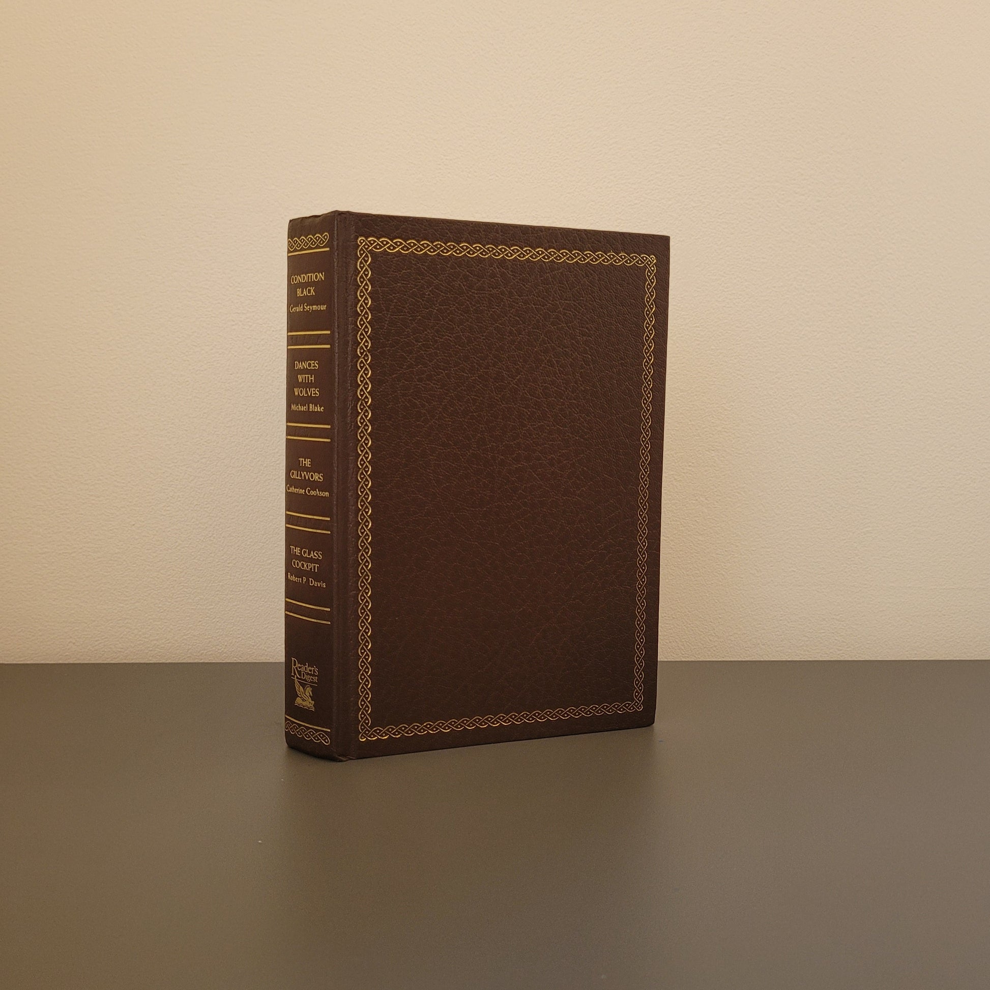 The front of the book fold - a brown hardback book with a gold border.