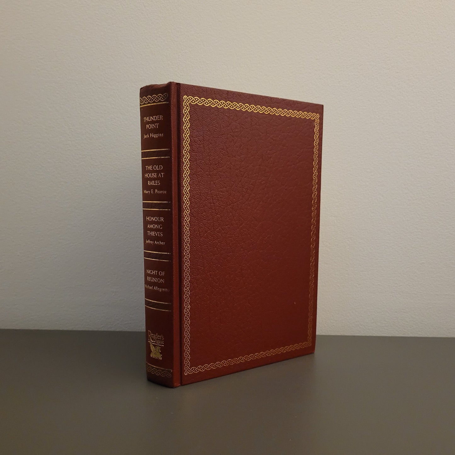 A picture of the front of the book fold - a hardback book with a gold border.