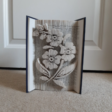 A picture of a book fold, with flowers on a stem on the front.